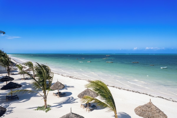On the beach, white sand, sun loungers, beach umbrellas