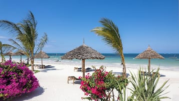 On the beach, white sand, sun-loungers, beach umbrellas