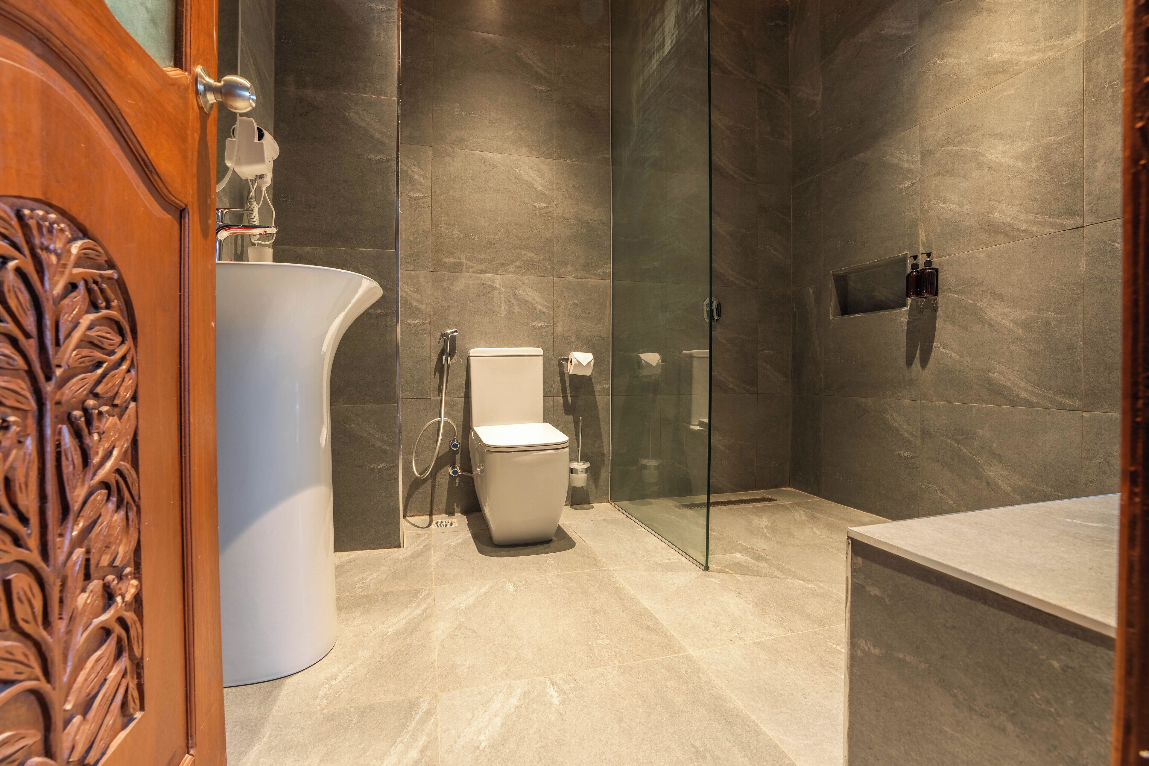 A modern bathroom with a toilet, sink, and shower area.