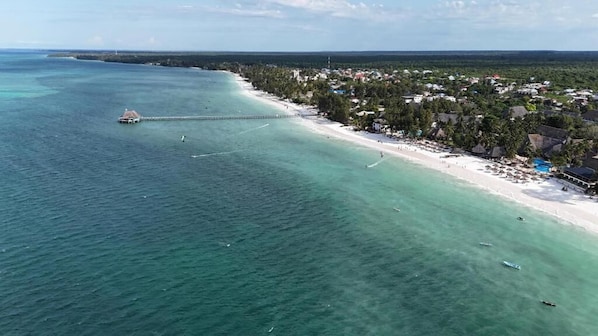 Am Strand, weißer Sandstrand, Liegestühle, Sonnenschirme