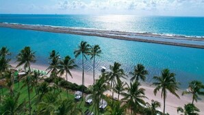 A beach view with palm trees and a clear sky. - Flat Porto Alto Resort, Porto de Galinhas   (N. São do Ó)