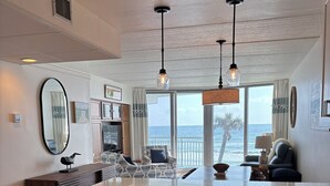 Una cocina amplia con una isla grande, piso de madera e iluminación colgante.