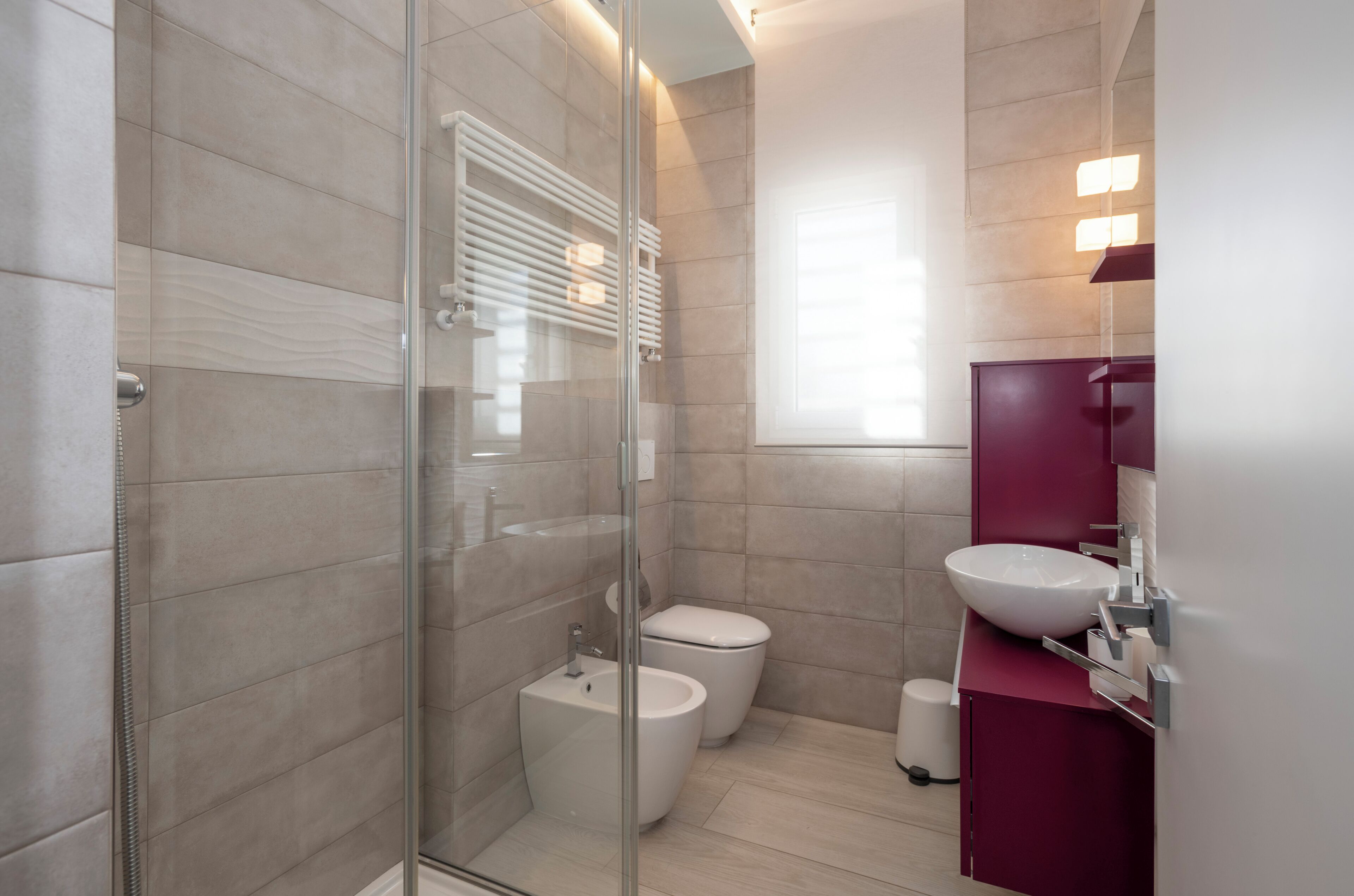 Une salle de bain moderne avec une douche à parois de verre, un lavabo blanc et des toilettes.