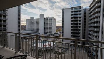 A view from a balcony overlooking a courtyard with a pool, surrounded by modern buildings.