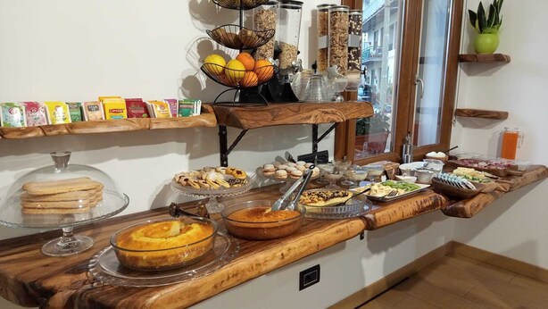 Un buffet proposant une variété de plats, notamment des pâtisseries, des fruits et des boissons.