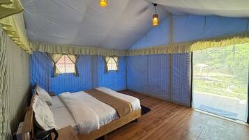 Ein Schlafzimmer mit einem hölzernen Bett, Vorhängen und Blick auf Grünflächen.