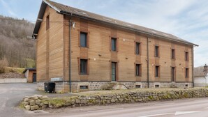 A large, two-story wooden building with multiple windows and a stone foundation.
