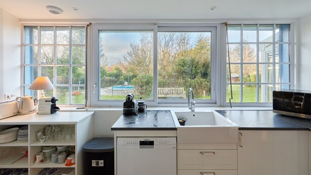 A modern kitchen with a large window, a dishwasher, and a microwave.