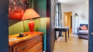 Una habitación con un aparador de madera, una lámpara roja y un cuadro en la pared.