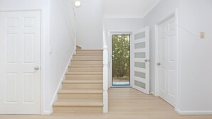 A staircase leading to a door with a view of trees outside.