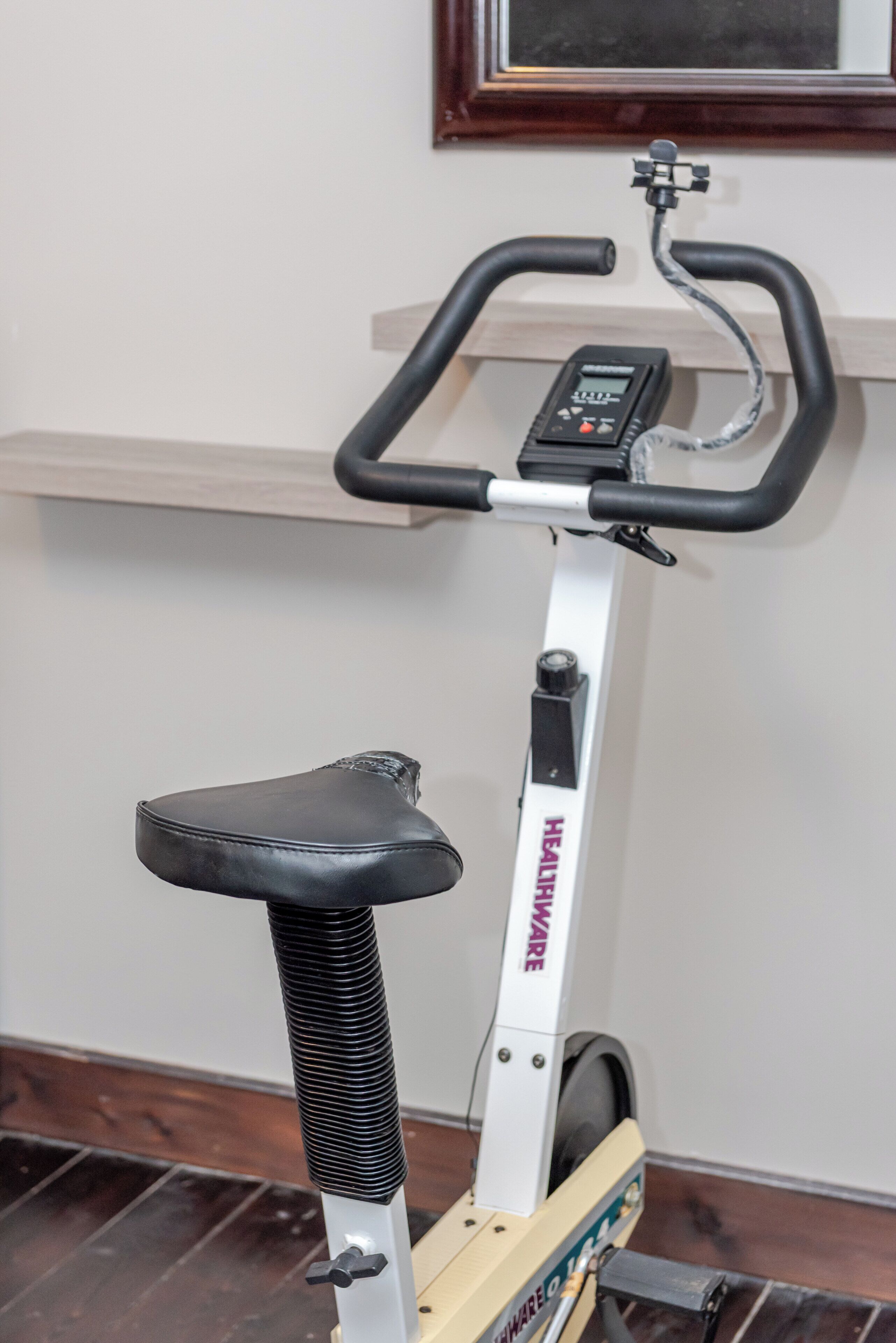 A stationary exercise bike with a digital display and a control panel.