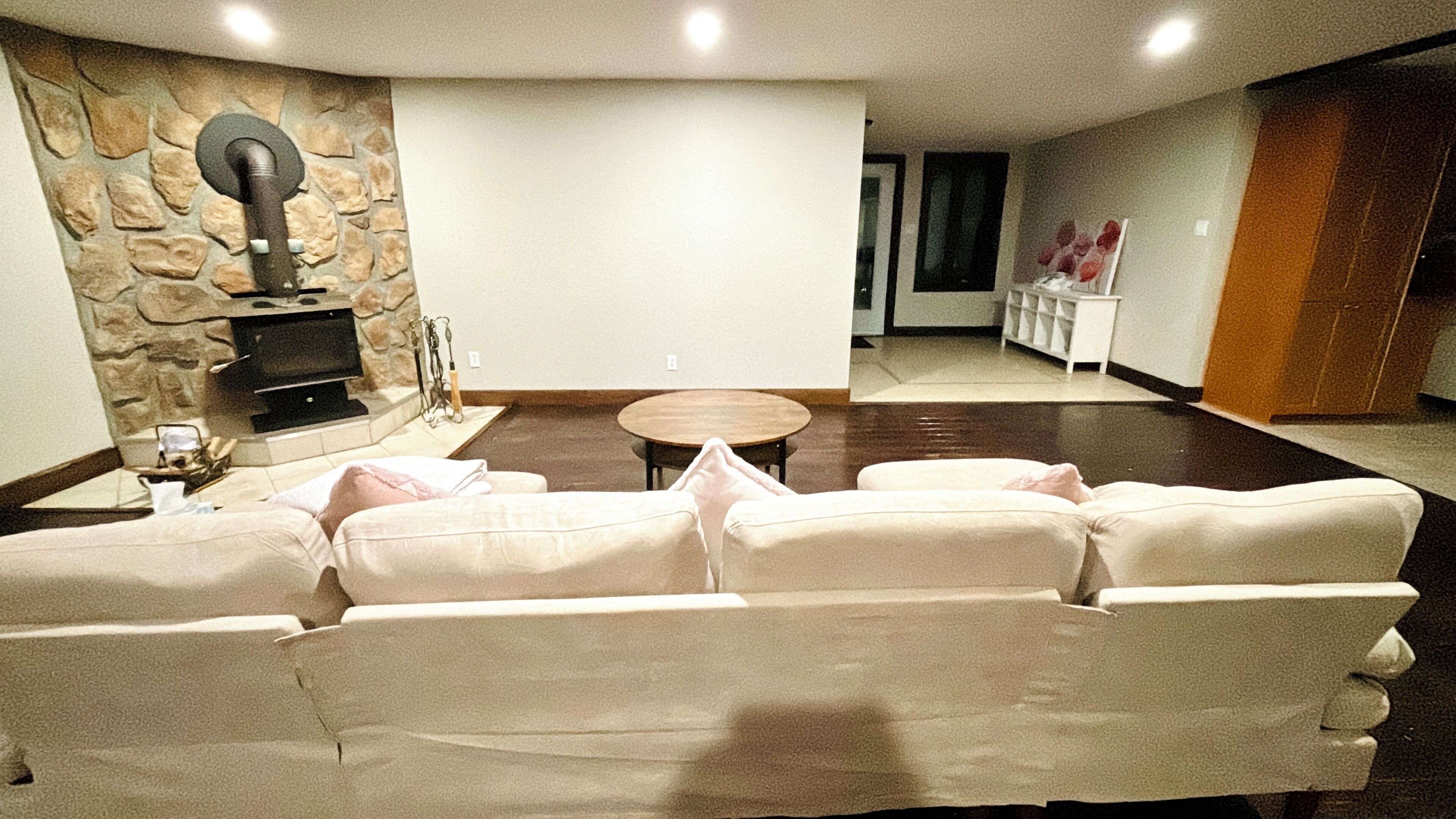 A living room with a stone wall, a fireplace, a sofa, and a coffee table.