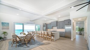A spacious kitchen with a large island, grey cabinets, and a stainless steel refrigerator. - Beautiful SeaCrown Estate-Oceanfront- 6BR 5.5BA with Pool (St Thomas)