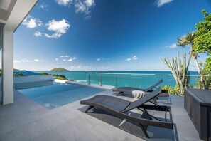 A poolside area with lounge chairs and a view of the ocean. - Beautiful SeaCrown Estate-Oceanfront- 6BR 5.5BA with Pool (St Thomas)