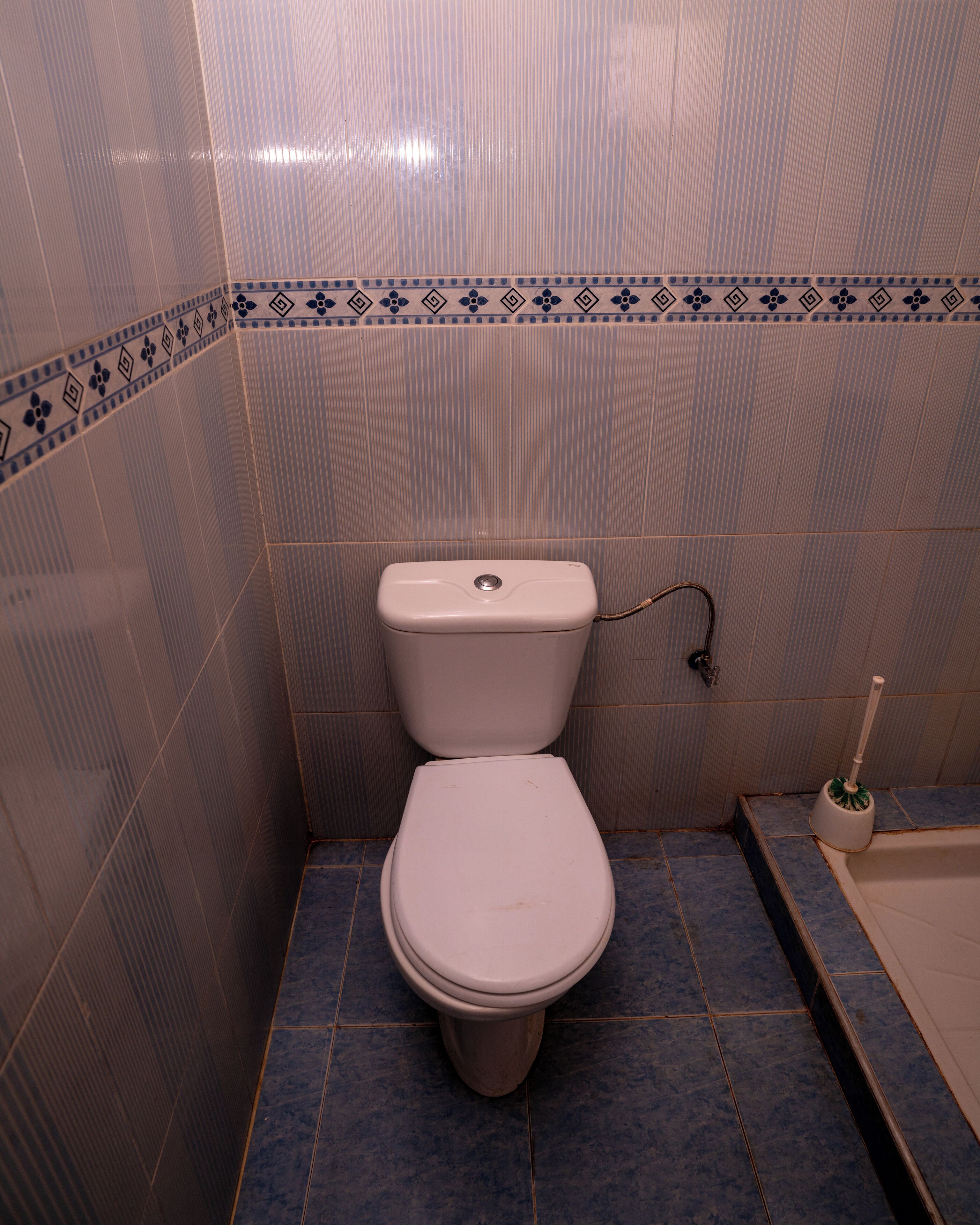 A bathroom with a toilet, a bidet, and a tiled floor.