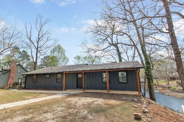 Situated by the water, this charming building features a front porch and a covered entryway.