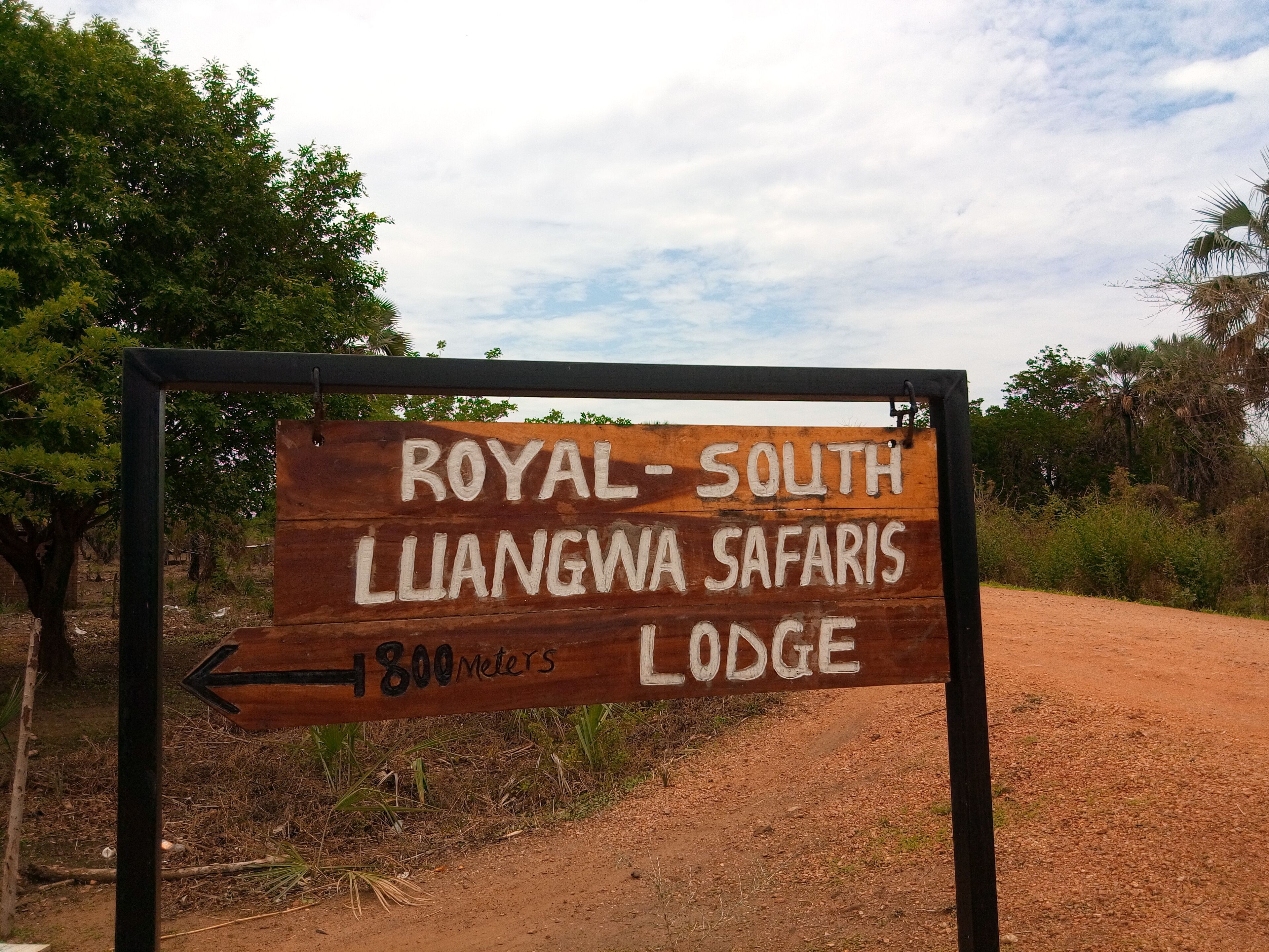 Indicador de fusta que mostra el camí cap a Royal-South Liangwa Safaris Lodge, a 800 metres.