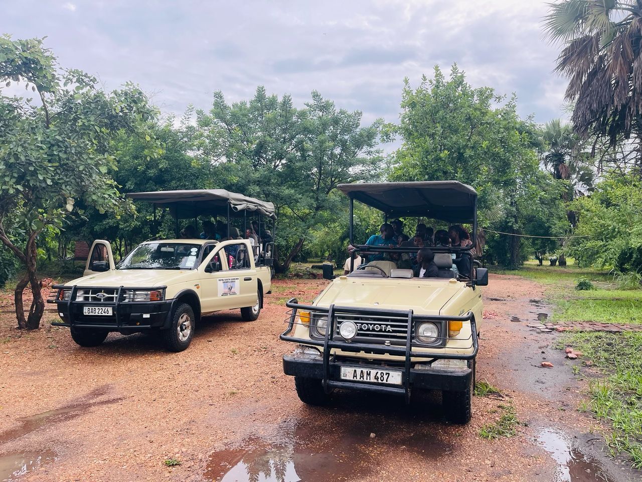 Two off-road vehicles parked on a muddy path in a natural setting.