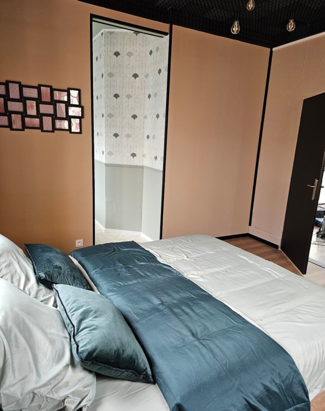A bedroom with a bed, pillows, a wardrobe, and a curtain.