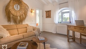 A cozy living room with a sofa, coffee table, and a laptop on a wooden table. - Villa BUENA VIDA by Abahana Villas (Javea / Xàbia)