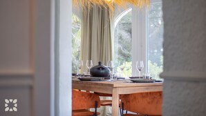 A dining area with a wooden table set for four, a black teapot, and wine glasses. - Villa BUENA VIDA by Abahana Villas (Javea / Xàbia)