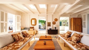 A spacious living room with a sofa set, wooden coffee table, and a view of the outdoors. - Villa Blanche with magnificent sea views and infinity pool at your disposal (Grand-Bourg)
