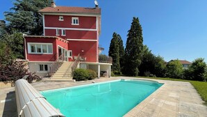 En swimmingpool med en rød bygning i baggrunden.