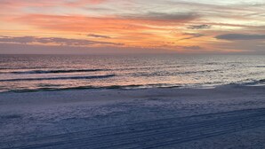 Een strand met golven en een zonsondergang.