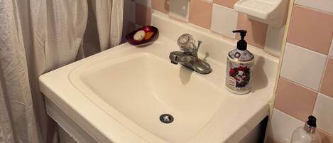 Secador de cabelo, toalhas de banho, sabonete, papel higiênico