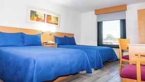 Une chambre d’hôtel avec deux lits, un bureau et une chaise.