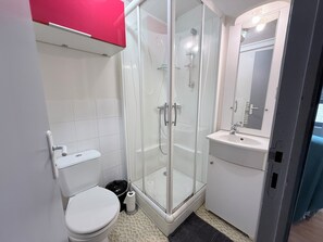 A bathroom with a toilet, a shower enclosure, and a sink. - Fully furnished and equipped studio apartment, right in the town center (limoges)