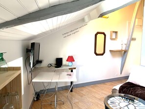 A room with a white desk, a red lamp, a clock, and a mirror on the wall. - Fully furnished and equipped studio apartment, right in the city center (limoges)