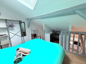 A room with a bed, a desk, a chair, and a small table. There is a window with a view of the outside. - Fully furnished and equipped studio apartment, right in the city center (limoges)