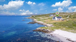 En fastighet vid kusten med ett hus och en strand.