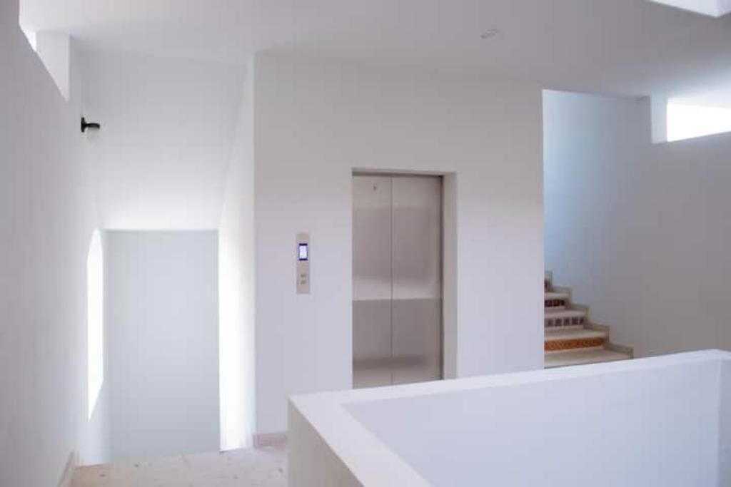 Ein modernes Interieur mit minimalistischem Design, mit Treppe, Tür und Aufzug.