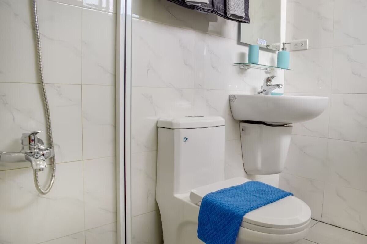 Un baño con ducha, inodoro y lavabo.