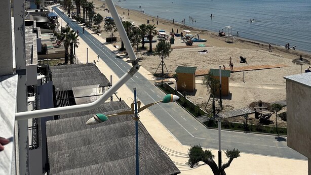 Un paisaje urbano costero con playa, edificios y cielo despejado.