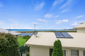 Een woonhuis met een schotelantenne, zonnepanelen en uitzicht op de oceaan.