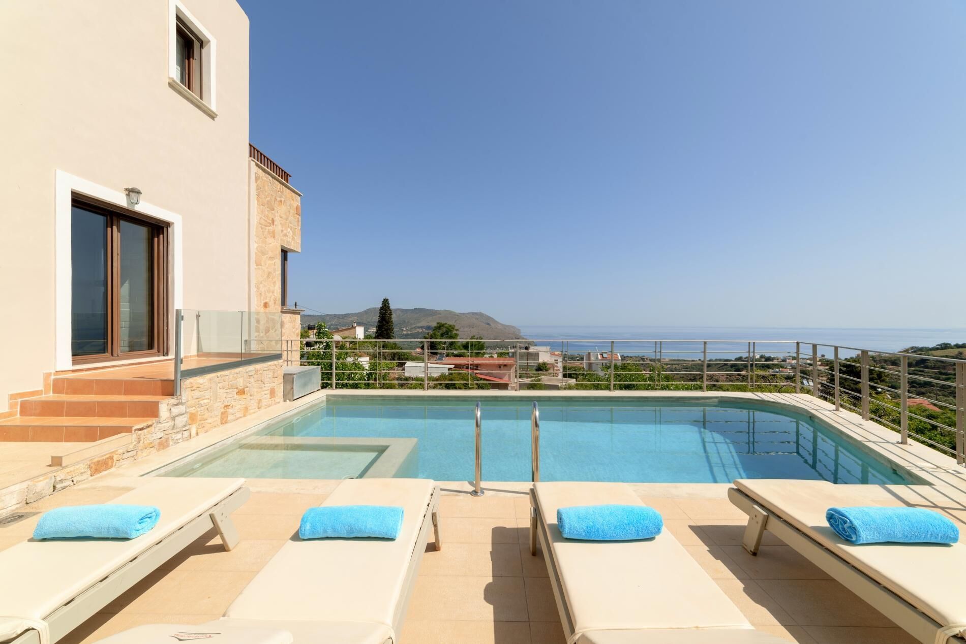 Una piscina en la azotea con sillas de descanso y vistas al mar.