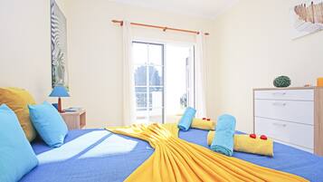 A hotel room with a bed, a desk, a chair, a wardrobe, and a window.