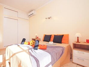 A bedroom with a bed, bedside tables, a lamp, and a nightstand.