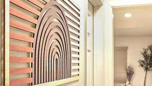 Een modern interieur met een houten wandpaneel en een trap naar een tweede verdieping.