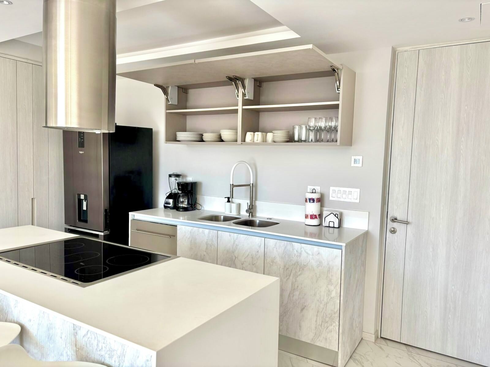 A modern kitchen with a built-in stove, a coffee maker, and a sink.