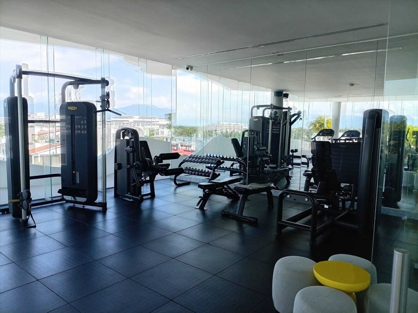 Una palestra con diverse macchine per esercizi, una panca e manubri.