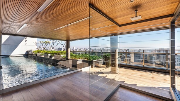 A modern indoor pool with wooden flooring and glass walls, offering a view of the city skyline. - 112 Rosemari's Apartments Studio Premium Centro SP Garage & Pool & Gym (República São Paulo)