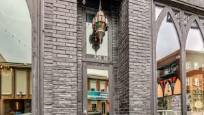Un bâtiment à la façade en briques, doté d’une grande fenêtre en arc de cercle et d’un luminaire décoratif suspendu.