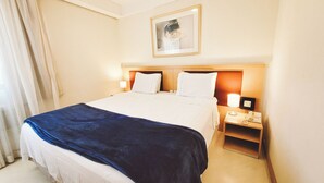 A hotel room with a bed, bedside lamps, a nightstand with a phone, and a framed picture on the wall. - piscina academia e manobrista (São Paulo)