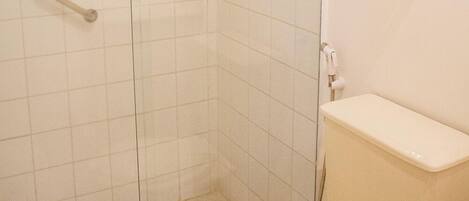 Een badkamer met een douchecabine, toilet en handdoekhouder.