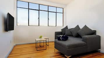 Departamento urbano, baño en la habitación | Sala de estar | Televisión de pantalla plana de 50 pulgadas con canales por cable