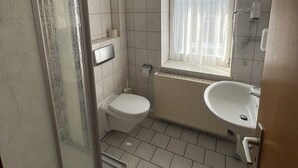 Ett badrum med dusch, toalett och handfat.